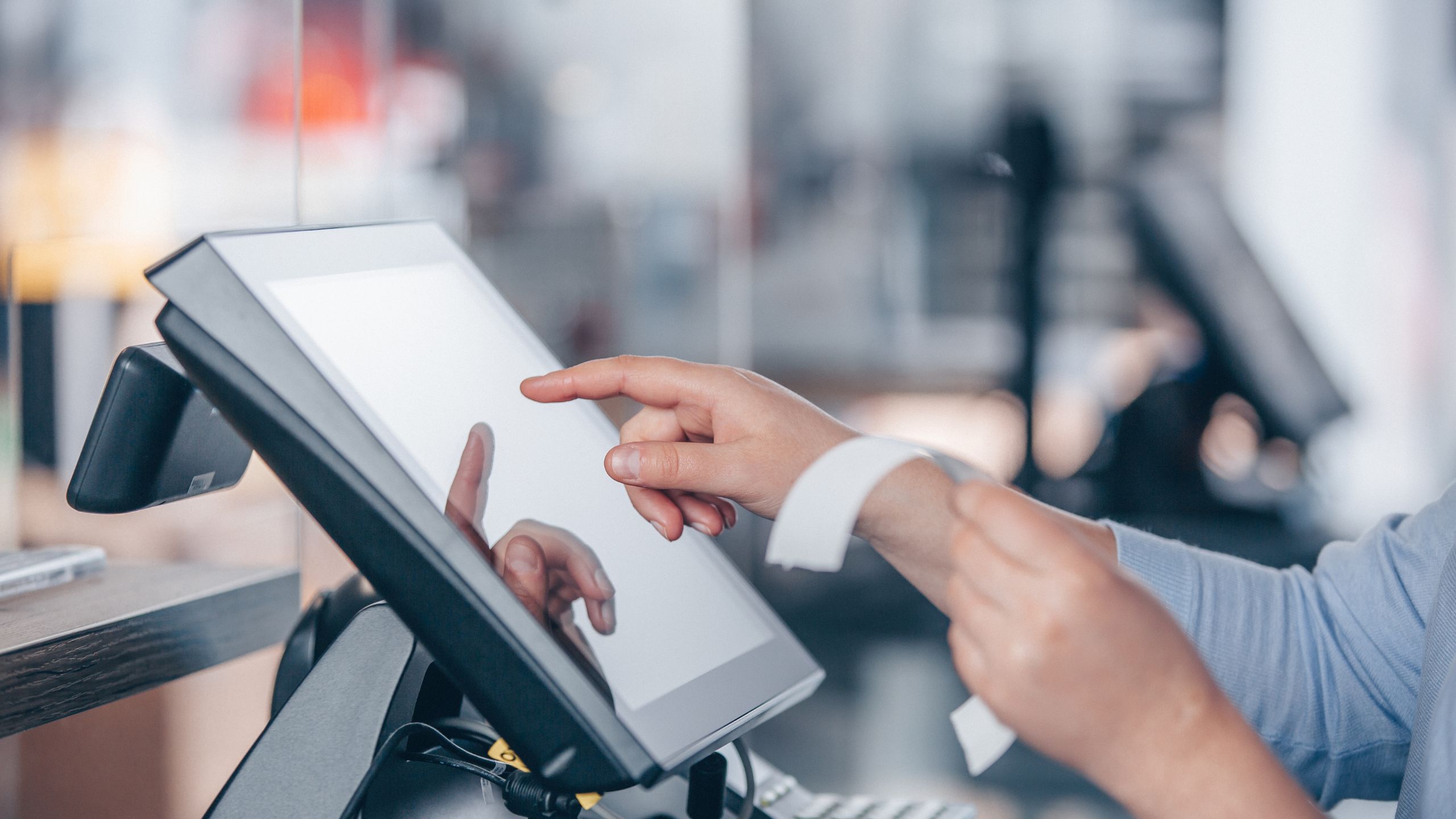 A male hand operating a supermarket pos system.